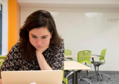 Woman looking down at laptop