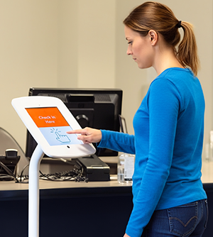 Woman at a kiosk checking in at a health center